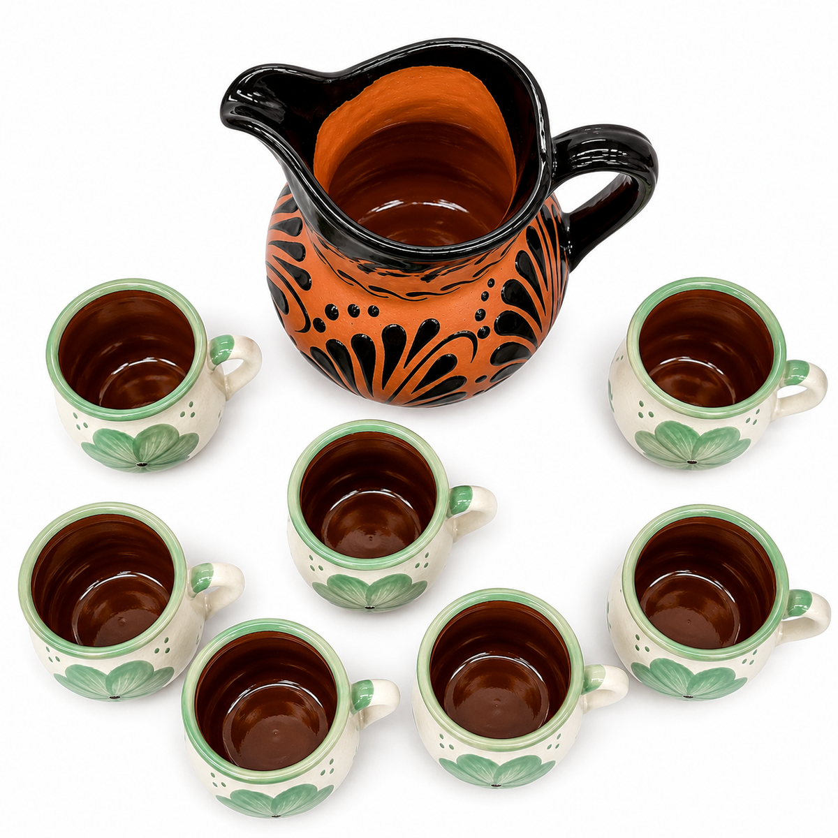 Ceramic pitcher and cups with decorative patterns on a white background