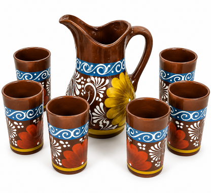 Ceramic pitcher and tumblers with floral designs on a white background