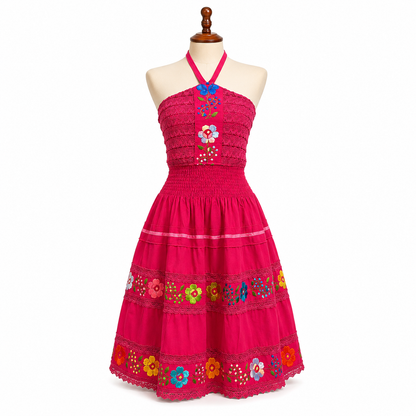 Pink dress with floral embroidery on a mannequin against a white background