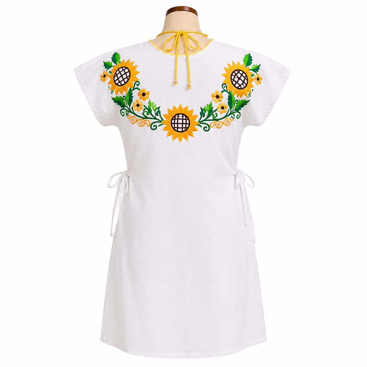 White dress with sunflower embroidery on a mannequin against a white background