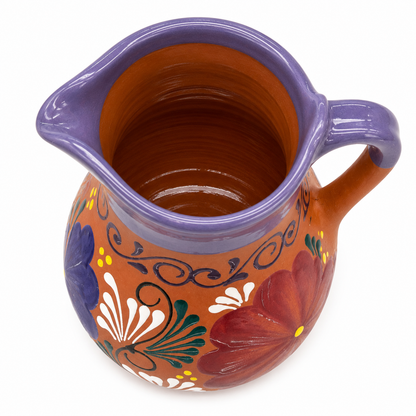 Ceramic pitcher with floral designs on a white background